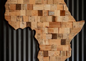 Artistic wooden map of Africa against dark corrugated background.